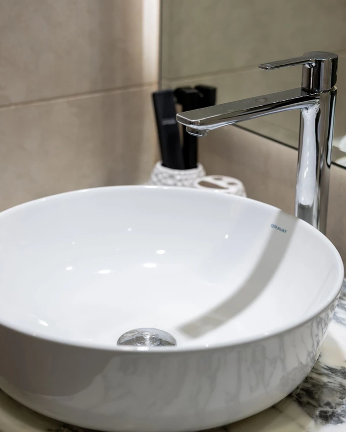 A glossy white refinished freestanding tub in a bright bathroom