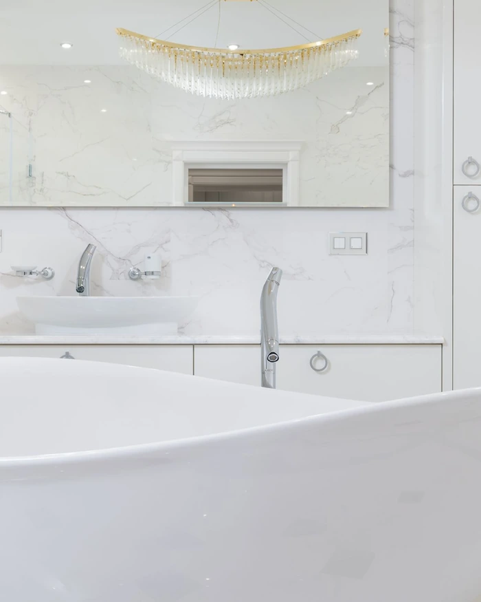 A clean white soaking tub against a tiled wall after refinishing